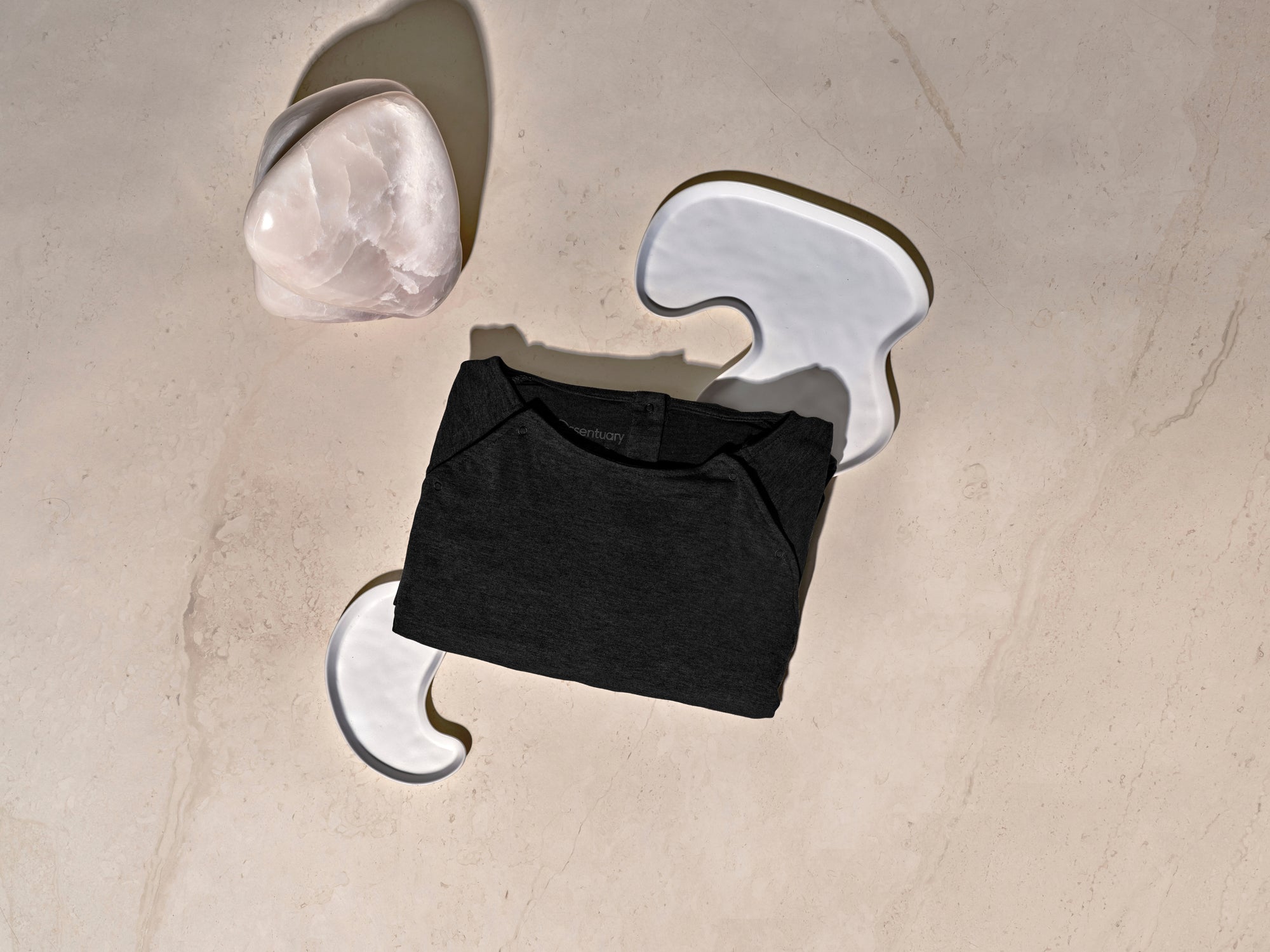 Zwarte bevallingsjurk opgevouwen, toont compacte formaat en label-vrij ontwerp om irritatie te voorkomen.