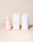 Peri Bottle ingeklapt met bijgeleverde stofvrije opbergzak en hygiënedop naast Essentuary verpakking.