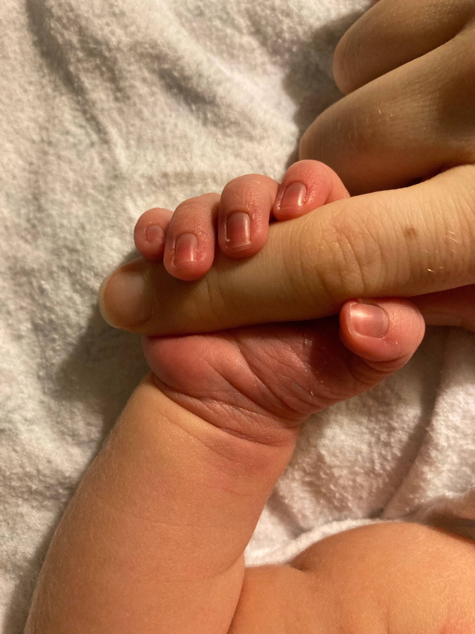 Rauwe waarheid over Postpartum Herstel: Kraamvrouw met pasgeboren baby handje