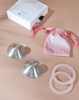 Foto van zilveren tepelhoedjes met dustbag, siliconen ringen en doosje voor kloven tijdens de borstvoedingsperiode