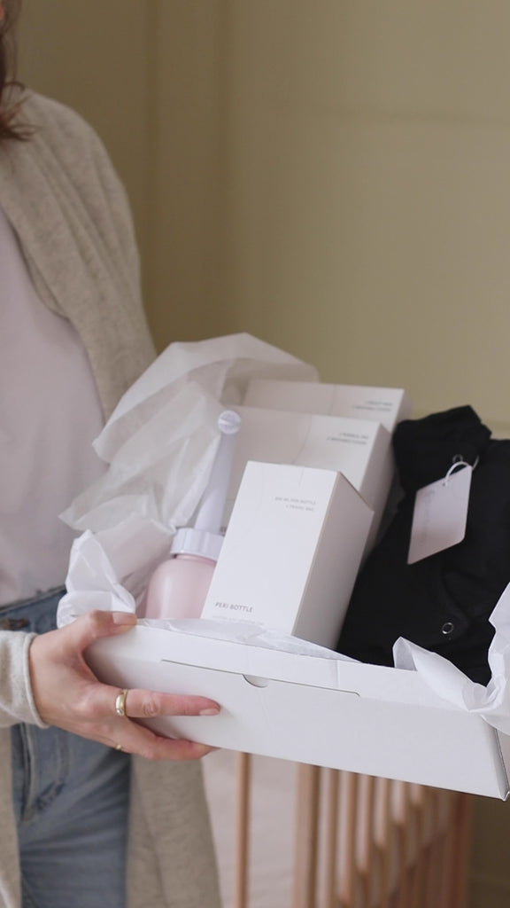 Video van de open Ode to Motherhood Box met praktische postpartum producten voor de eerste weken na de bevalling, inclusief peri bottle, bevallingsjurk en kompressen.