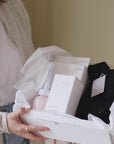 Video van de open Ode to Motherhood Box met praktische postpartum producten voor de eerste weken na de bevalling, inclusief peri bottle, bevallingsjurk en kompressen.